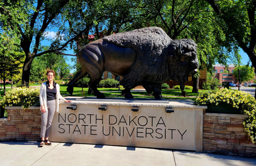 College student standing next to buffalo statue