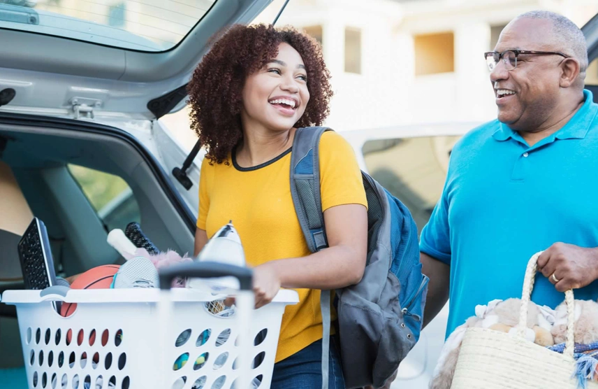 Your guide to living on campus. Father and daughter unpacking the car for the dorm room.