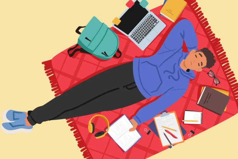 The power of a productive break. Image of a student, relaxing on a blanket, surrounded by a laptop, backpack, and schoolwork.